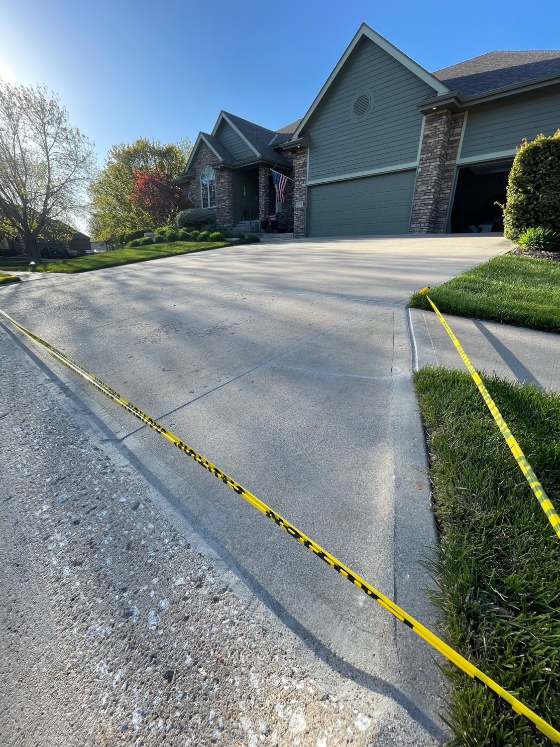 Suburban driveway with American flag and caulked joints