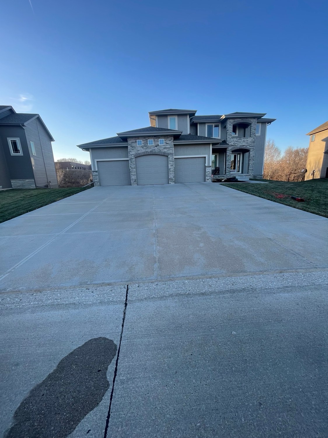 Luxury stone-front 3-car garage driveway in Omaha after caulking