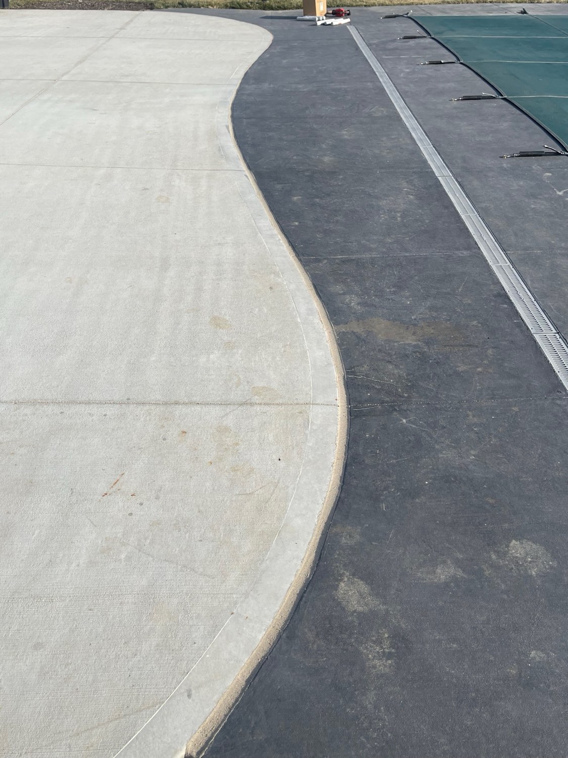 Pool deck expansion joint with curved caulk line